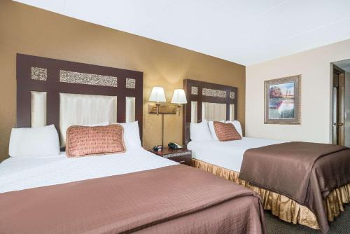 a hotel room with two beds in a room at Ramada by Wyndham Plymouth Hotel & Conference Center in Plymouth