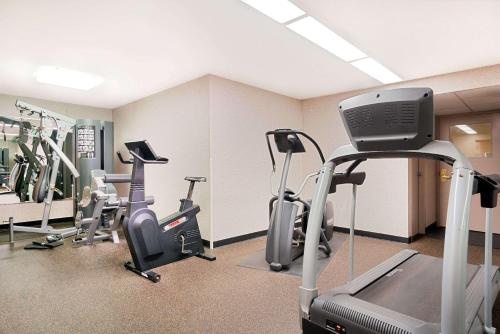 a gym with treadmills and elliptical machines at Ramada by Wyndham Plymouth Hotel & Conference Center in Plymouth