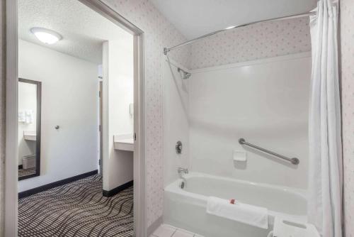 a bathroom with a tub and a toilet and a sink at Ramada by Wyndham Coeur d'Alene in Coeur d'Alene