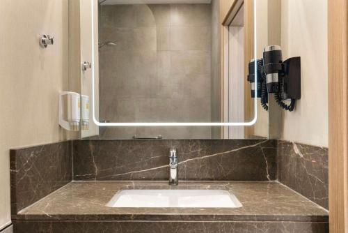 y baño con lavabo y espejo. en Ramada Encore Eskişehir, en Eskisehir