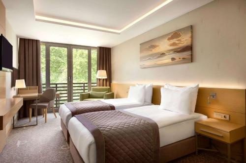 a hotel room with two beds and a balcony at Ramada By Wyndham Bursa Cekirge Thermal & Spa in Bursa