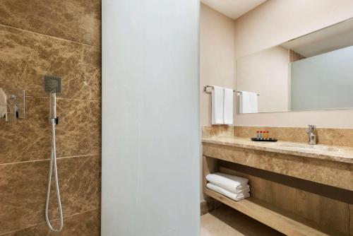 a bathroom with a shower and a sink at Ramada Encore Gebze in Gebze