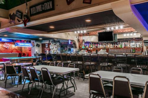 a restaurant with tables and chairs and a bar at Ramada by Wyndham Odessa Near University of Texas Permian in Odessa