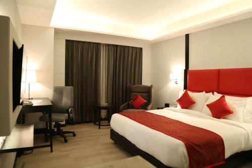 a hotel room with a large bed and a desk at Ramada Encore Jalandhar in Jalandhar