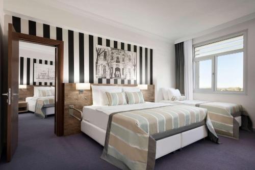 a hotel room with two beds and a window at Ramada Hotel by Wyndham Edirne in Edirne