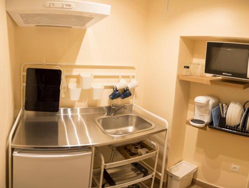 a small kitchen with a sink and a tv at La Casa Del Recreo in Cómpeta