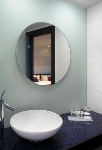 a bathroom with a white sink and a mirror at Park Plaza Leeds in Leeds