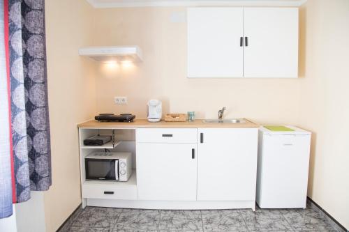 a kitchen with a sink and a microwave at La Casa Del Recreo in Cómpeta