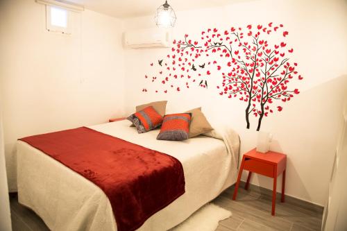 a bedroom with a bed with a tree on the wall at La Casa Del Recreo in Cómpeta