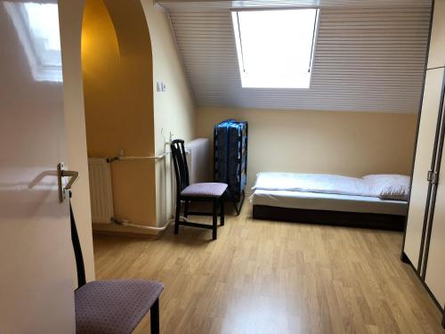 a bedroom with a bed and a window and a chair at Napsugár Vendégház in Kehidakustány