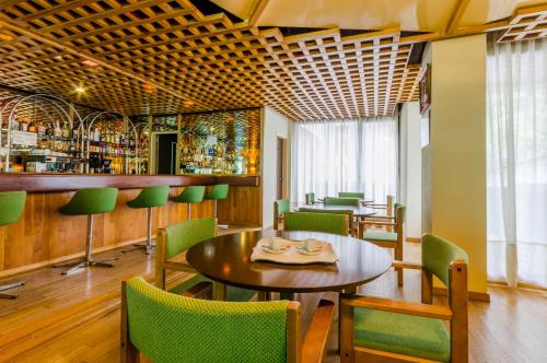 um restaurante com mesa e cadeiras e um bar em Hotel Sant Eloi em Sant Julià de Lòria