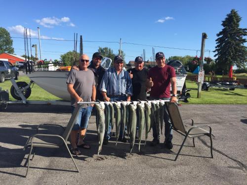 a group of people standing next to a table with fish at Budget Inn in Port Hope