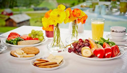 einen Tisch mit Teller mit Lebensmitteln und Vasen mit Blumen in der Unterkunft Storefjell Resort Hotel in Gol