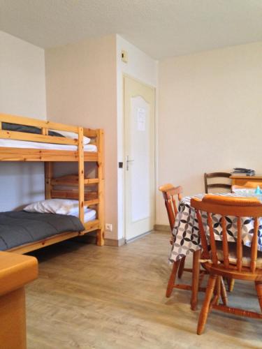 a bedroom with a bunk bed and a table and chairs at Appartement tout confort in Argelès-Gazost