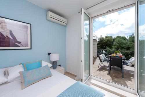 1 dormitorio con 1 cama y puerta corredera de cristal en Dream Estate, en Dubrovnik