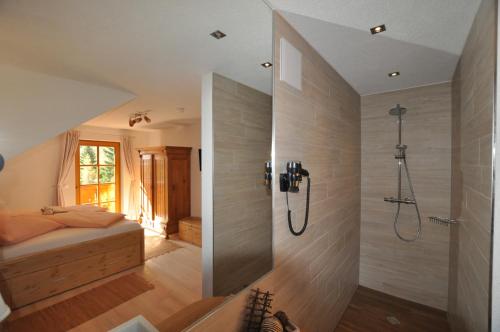 ein Bad mit Dusche und ein Bett in einem Zimmer in der Unterkunft Chalet Styria in Donnersbachwald