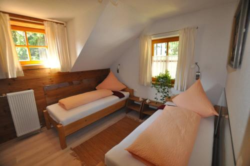a attic room with a couch and two windows at Chalet Styria in Donnersbachwald