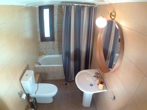 a bathroom with a toilet and a sink and a mirror at Mezapos Villa Katerina in Mézapos