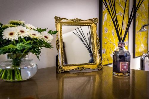 a bottle of whiskey sitting on a table with a mirror at Palazzo Ridolfi - Residenza d'Epoca in Florence