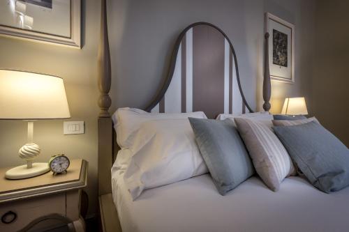 a bedroom with a bed with pillows and a clock at Palazzo Ridolfi - Residenza d'Epoca in Florence