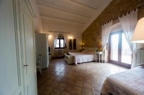 a bedroom with a bed and a large window at Nacalino Agriturismo in Modica