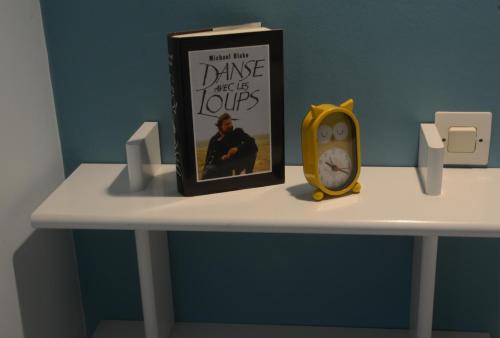 a book sitting on top of a table with a clock at Les Rendzines in Nuisement-sur-Coole