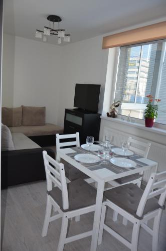 a white dining table and chairs in a living room at Apartments Ozo Park in Vilnius