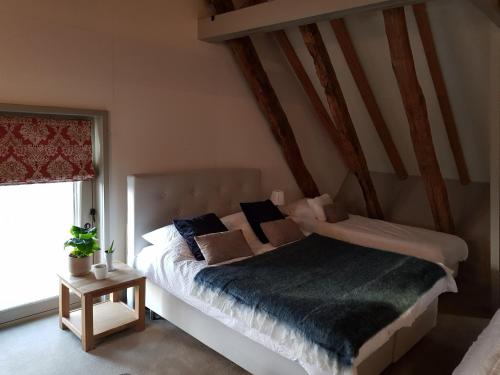 een slaapkamer met een bed met kussens erop bij Landgoed De Lavei in Weleveld