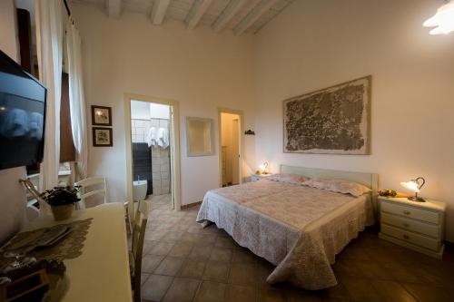 a bedroom with a bed and a flat screen tv at Nacalino Agriturismo in Modica