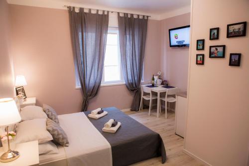 een slaapkamer met een bed, een tafel en een raam bij Diocletian's Palace Apartments in Split