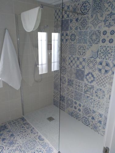 a shower with blue and white tiles on the wall at La Casa Del Recreo in Cómpeta