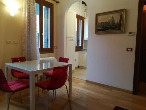 ヴェネツィアにあるCasa Contarinaのダイニングルーム(白いテーブル、赤い椅子付)