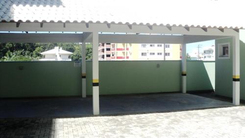 a green building with awning and a brick patio at AP IVONETE -Victoria Residense in Governador Celso Ramos