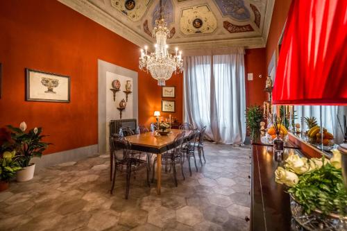 a dining room with a table and a chandelier at Palazzo Ridolfi - Residenza d'Epoca in Florence