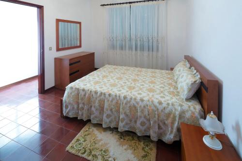 Un dormitorio con una cama, una cómoda y un espejo. en Lobos Rustic House II, en Câmara de Lobos
