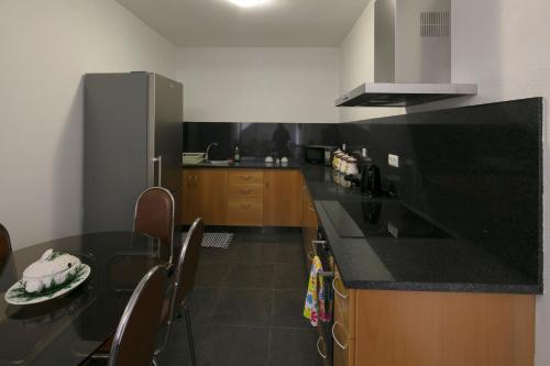 una cocina con encimera negra y armarios de madera en Lobos Rustic House II, en Câmara de Lobos