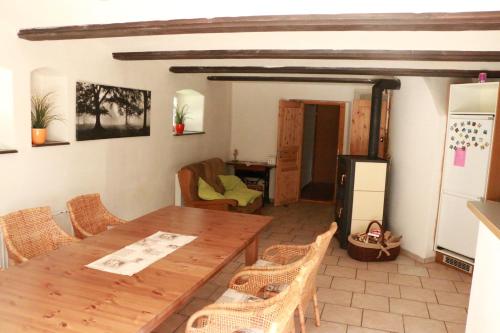 a dining room with a wooden table and chairs at Roubenka nad řekou in Noviny pod Ralskem