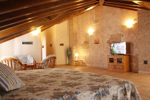 1 dormitorio con 1 cama y TV en una habitación en Casa Rural La Fragua en Guadalix de la Sierra