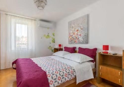 um quarto com uma cama grande e um cobertor roxo em Oko em Split