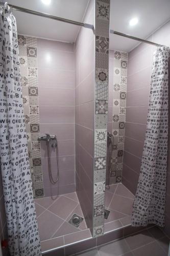 a shower with a glass door in a bathroom at Bloom Inn in Niš