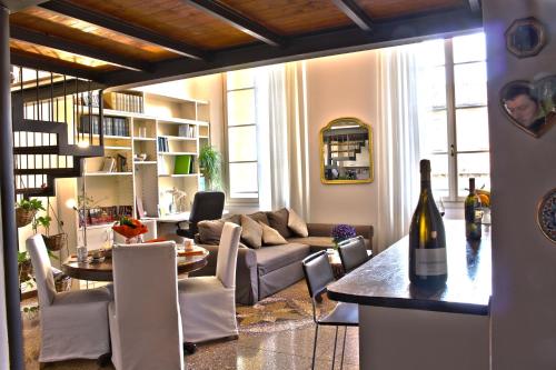 Sala de estar con sofá y mesa con botella de vino en Palazzo Bernacchi Open Space en Bolonia