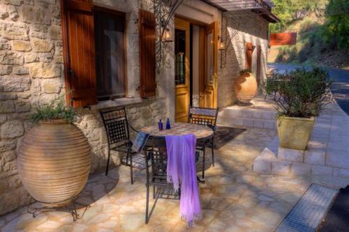 a patio with a table and chairs and a building at Methexis Boutique Hotel in Dhimitsana