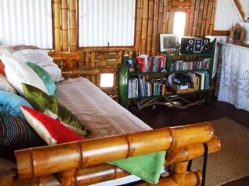 バイーア・フォルモーザにあるPousada Sabambugiのベッドルーム1室(木製ベッド1台、カラフルな枕付)