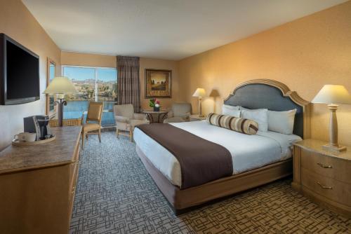 ラフリンにあるGolden Nugget Laughlinの大型ベッドとテレビが備わるホテルルームです。