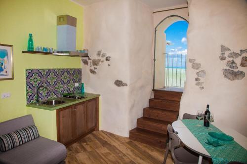 eine Küche mit einem Waschbecken und einem Tisch mit einem Tisch in der Unterkunft Balcone sulla spiaggia in Cefalú