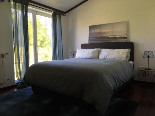 プライア・デ・ミラにあるVilla Coloane - Family Vacation Houseのベッドルーム(大型ベッド1台、大きな窓付)