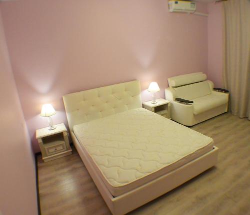 a small bedroom with a bed and a chair at 220 Apartment on Staroobrydcheskaya in Adler