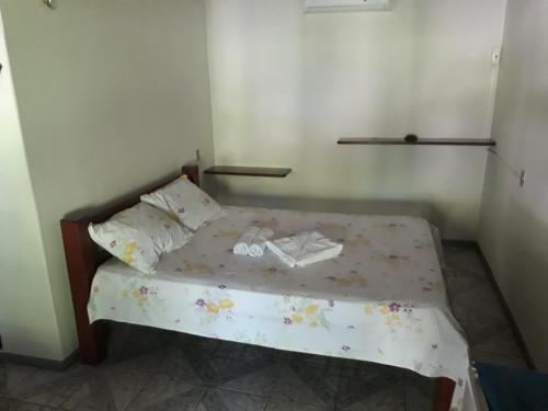 a small bed in a small room with at Pousada Aconchego in Mundaú