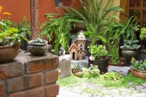 a miniature garden with a house and potted plants at "LLipimpac Guesthouse" in Cusco