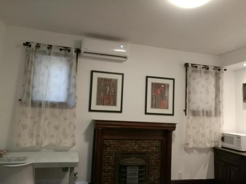 sala de estar con chimenea y cortinas en Ambassador's Inn Next Door, en Stratford